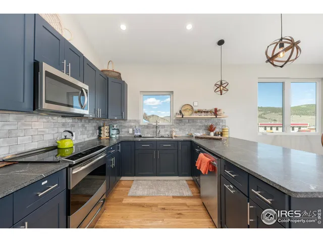 a kitchen with stainless steel appliances kitchen island granite countertop a sink table and chairs