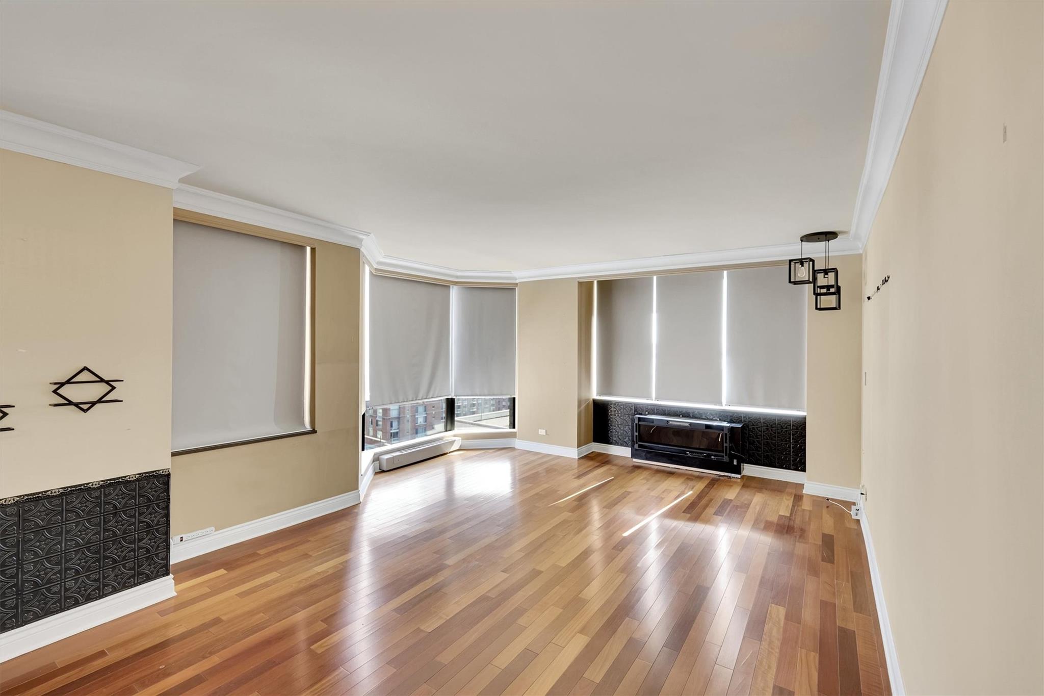 380 Rector Place, Unit 15E Manhattan, NY 10280 - Photo 15 of 31 Unfurnished room with crown molding, baseboards, and wood-type flooring