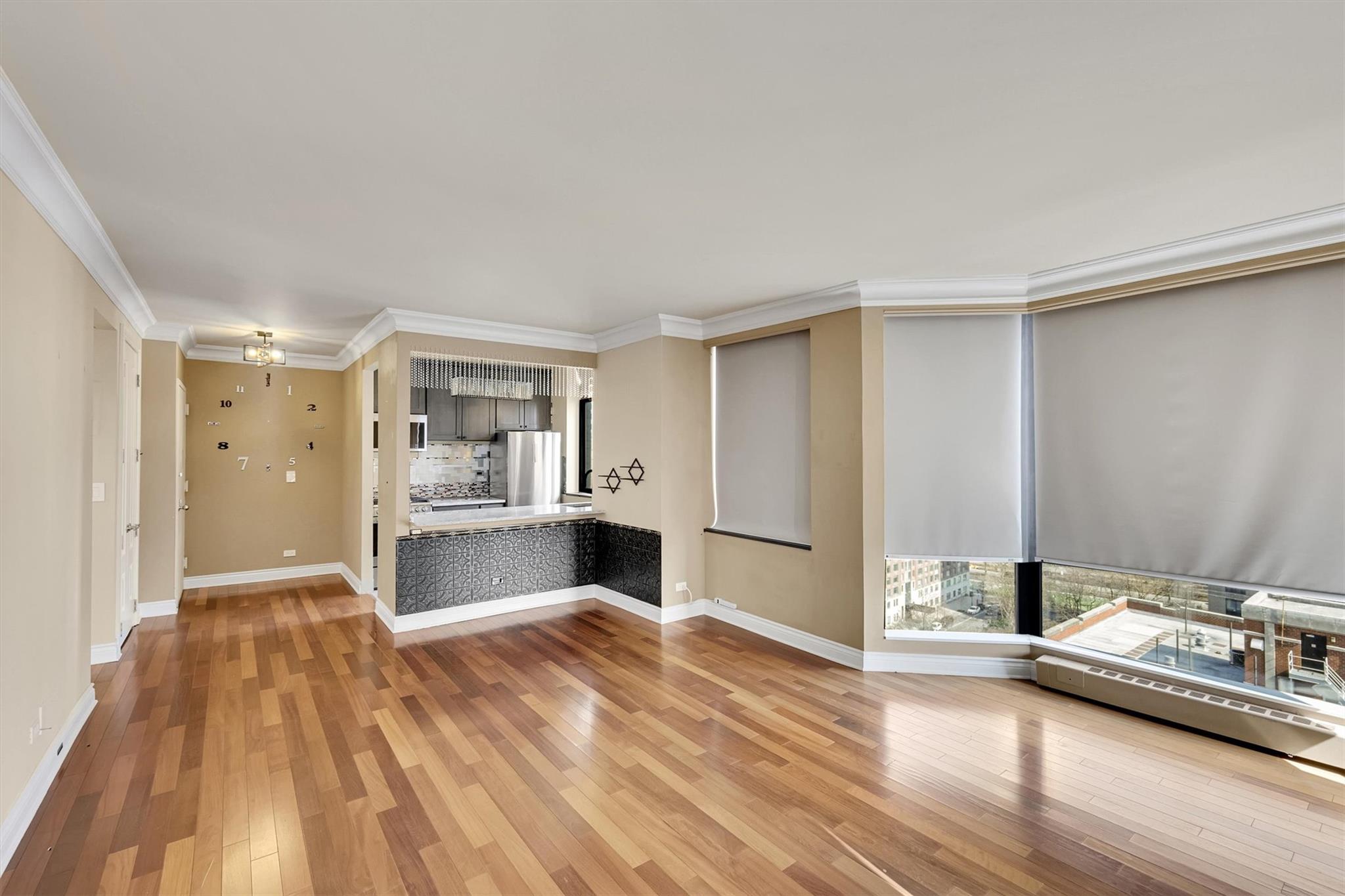 380 Rector Place, Unit 15E Manhattan, NY 10280 - Photo 17 of 31 Unfurnished living room with crown molding, light wood-type flooring, and baseboards