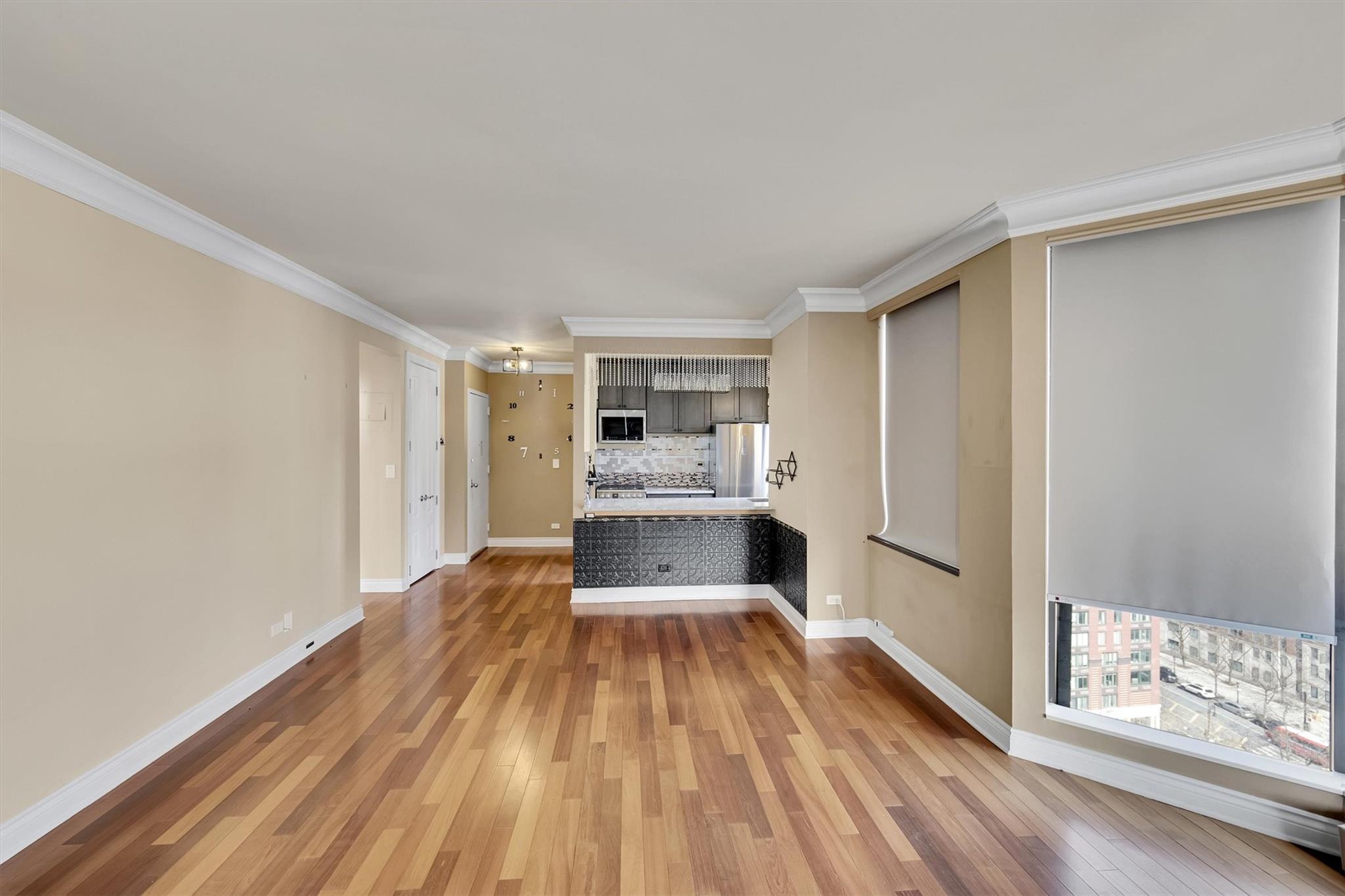 380 Rector Place, Unit 15E Manhattan, NY 10280 - Photo 18 of 31 Unfurnished living room featuring ornamental molding, baseboards, and wood-type flooring