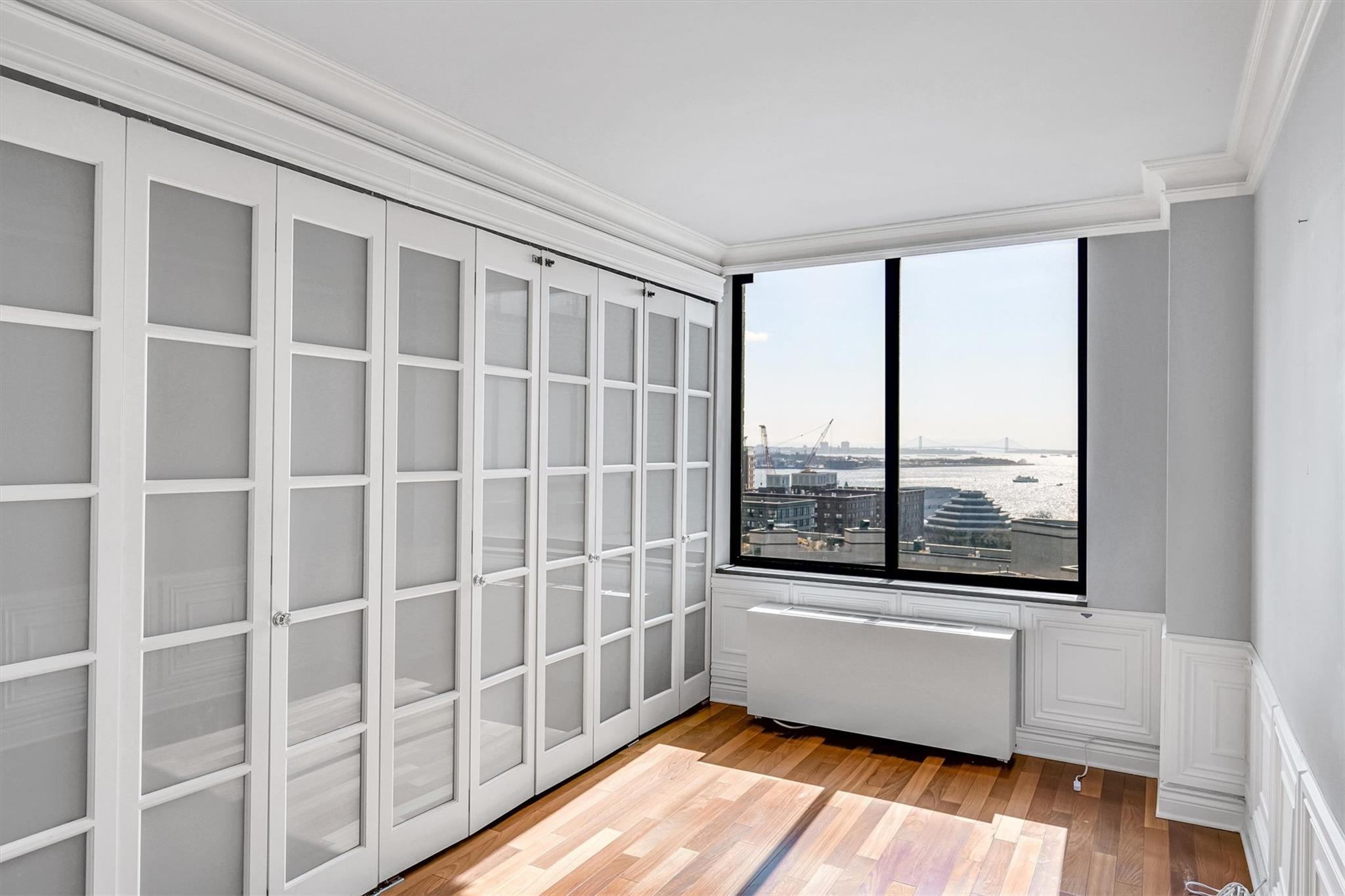 380 Rector Place, Unit 15E Manhattan, NY 10280 - Photo 23 of 31 Unfurnished room featuring crown molding and wood finished floors