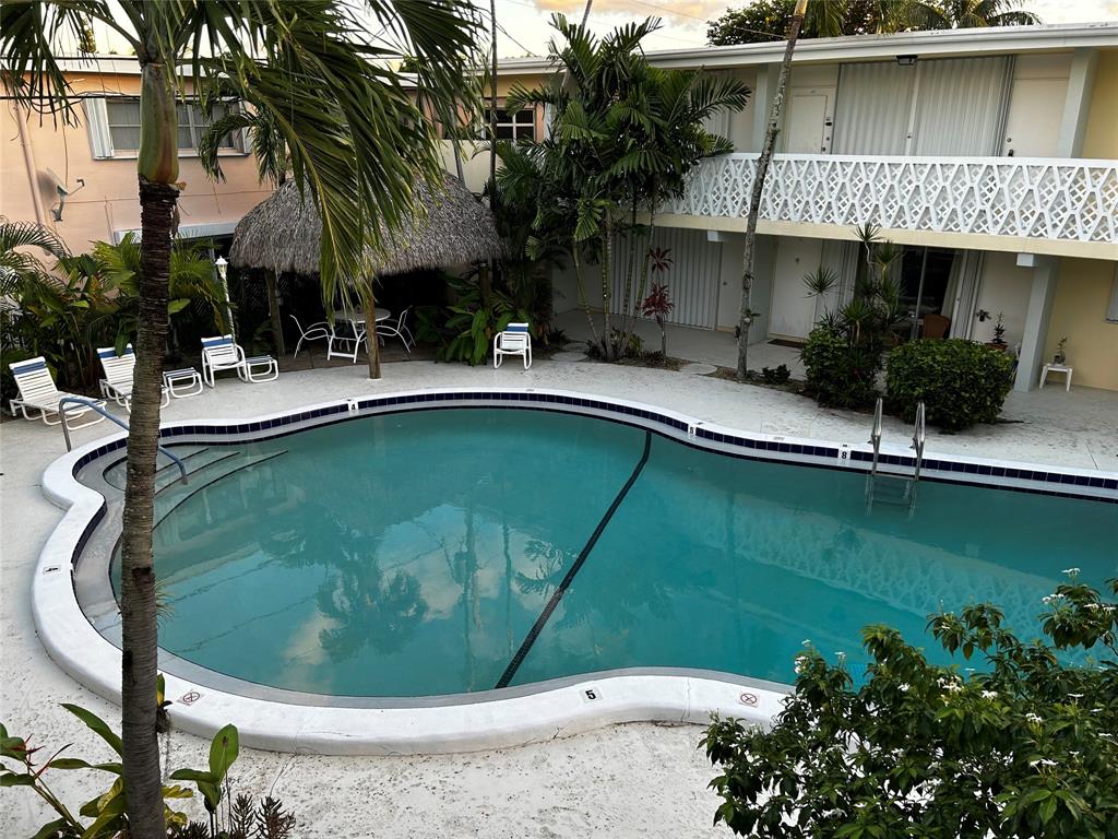 4630 Poinciana Street, Unit 1C Lauderdale-by-the-Sea, FL 33308 - Photo 1 of 7 a swimming pool with outdoor seating and yard