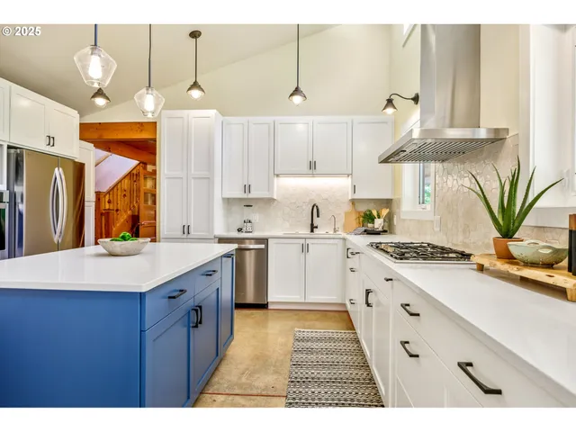 a kitchen with a white wooden cabinets sink and stove