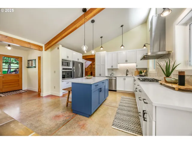 a kitchen with stainless steel appliances kitchen island granite countertop a sink and cabinets