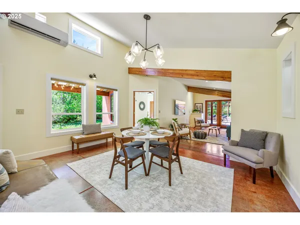 a living room with furniture a chandelier and a dining table
