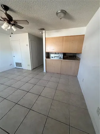 a kitchen with granite countertop a stove top oven sink and cabinets