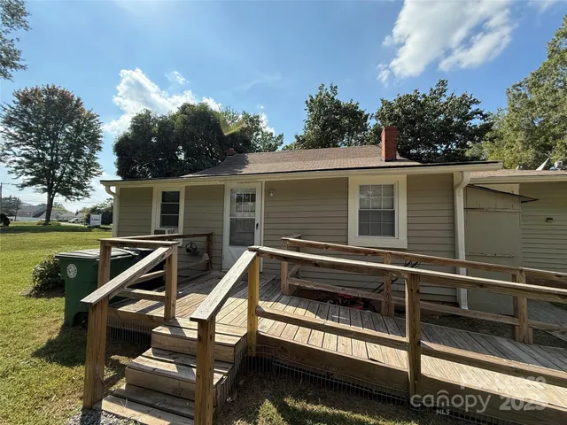 a view of a house with a deck and a backyard