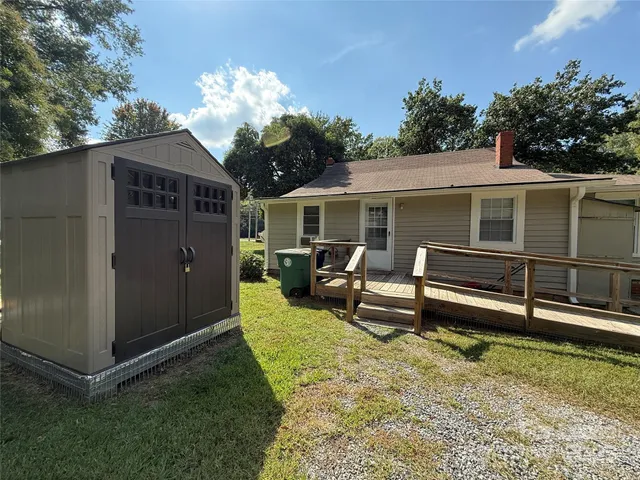 a view of a house with backyard and sitting area