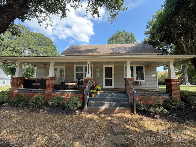 a view of a house with backyard sitting area and garden