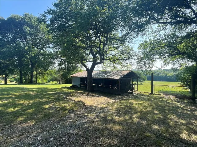 a view of a house with a yard and a large tree
