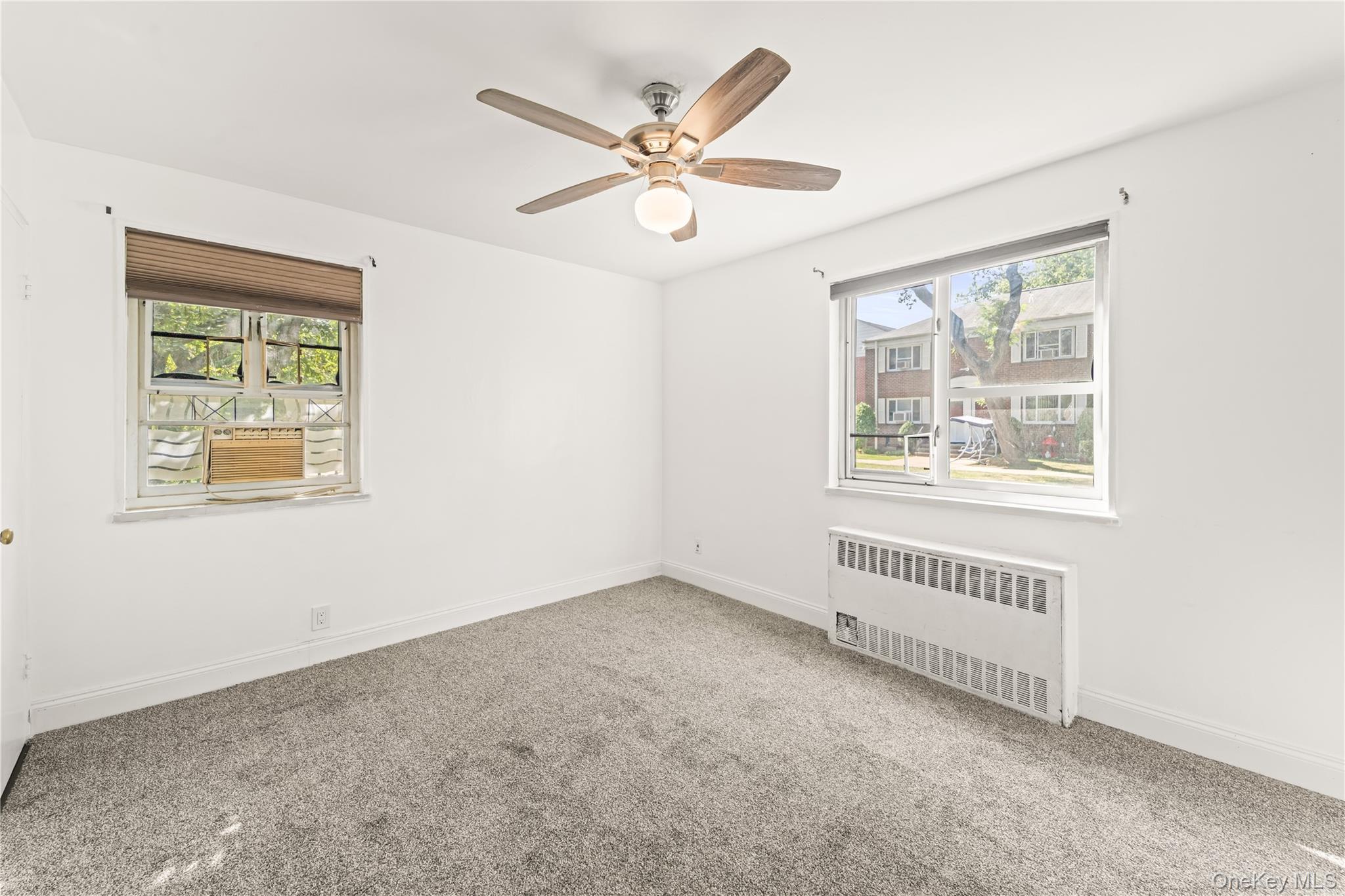 225-35 88th Avenue, Unit LOWR Queens, NY 11427 - Photo 5 of 15 an empty room with ceiling fan and windows