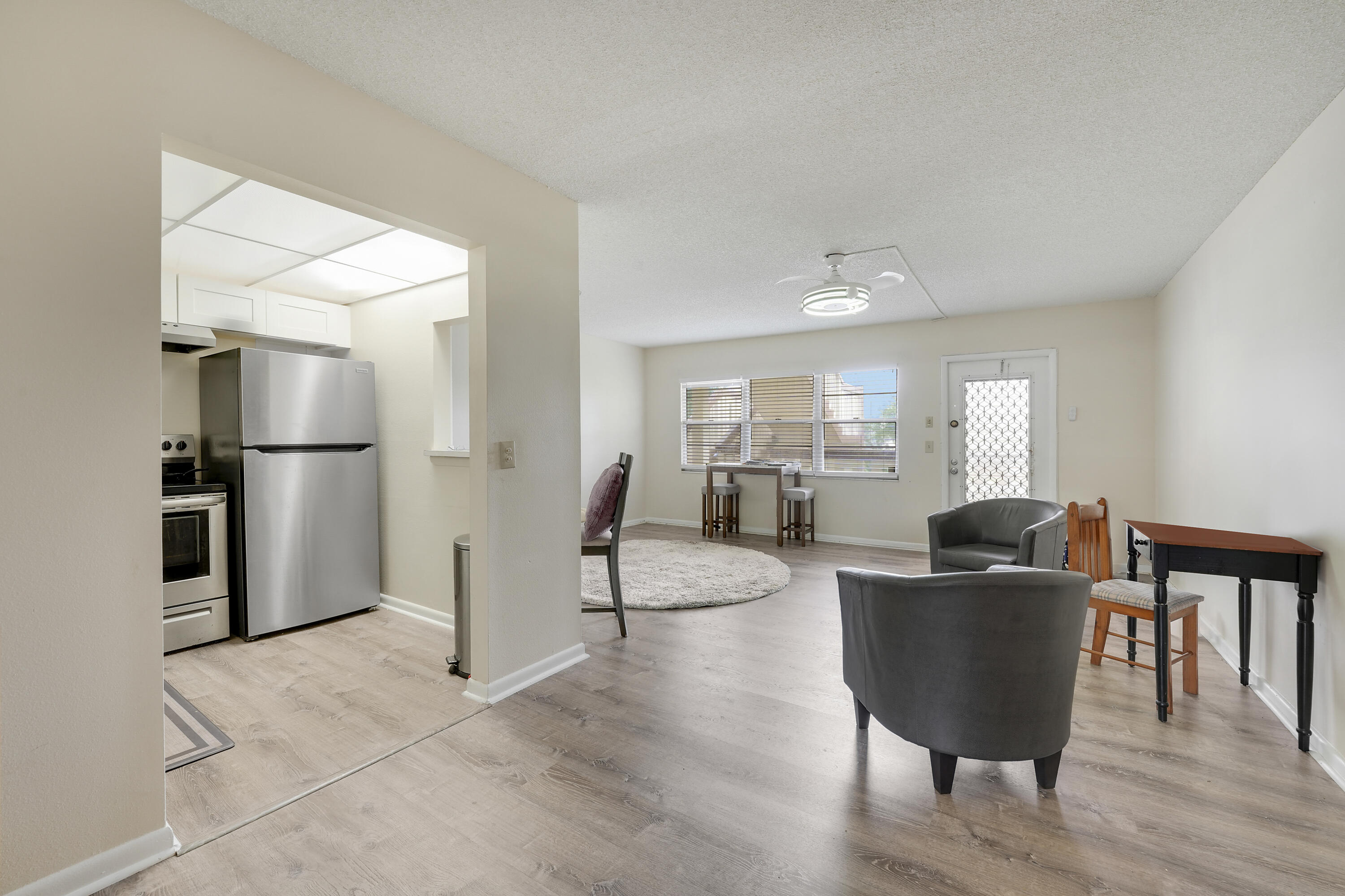 16 Mansfield B Boca Raton, FL 33434 - Photo 8 of 15 a living room with furniture and a dining table with kitchen view