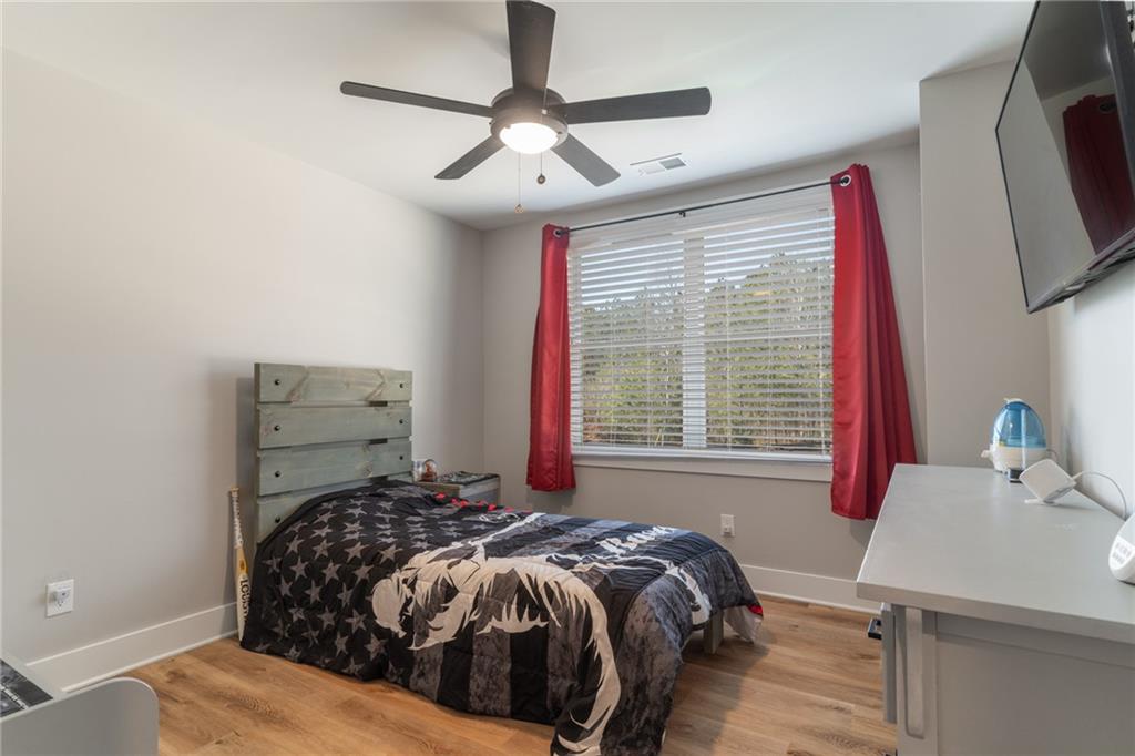 2250 Sperin Road Ball Ground, GA 30107 - Photo 45 of 56 a bedroom with a bed next to a window with a flat screen tv