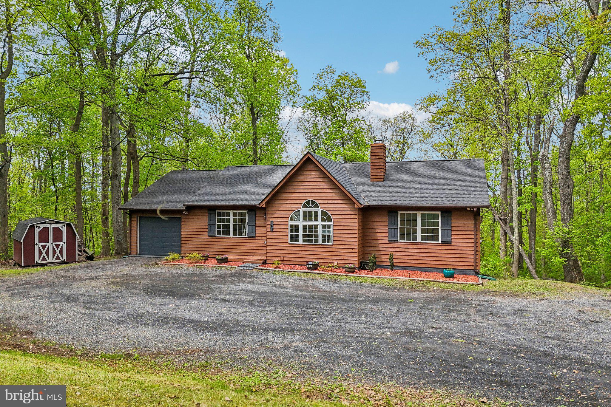 a view of a house with a yard and large trees