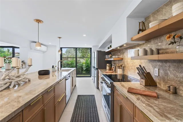 a kitchen with stainless steel appliances granite countertop a sink a stove and a wooden floors