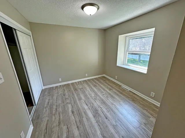 a view of room with window and wooden floor