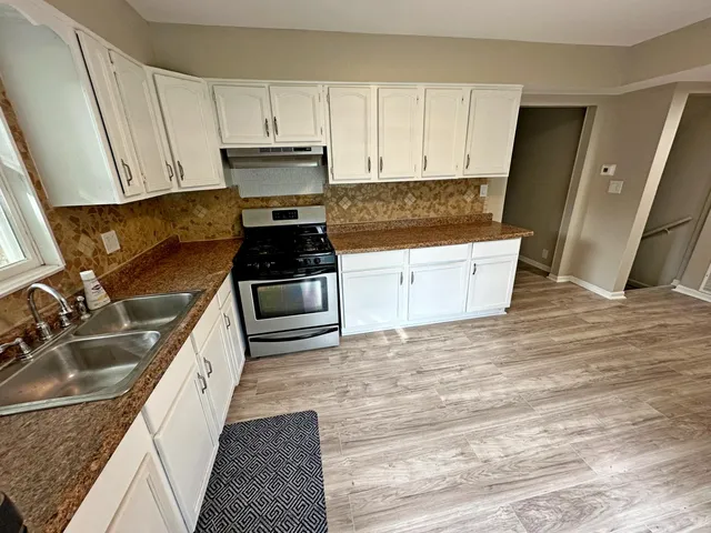 a kitchen with a sink stove and cabinets