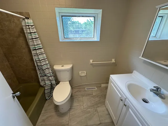 a bathroom with a toilet sink and mirror