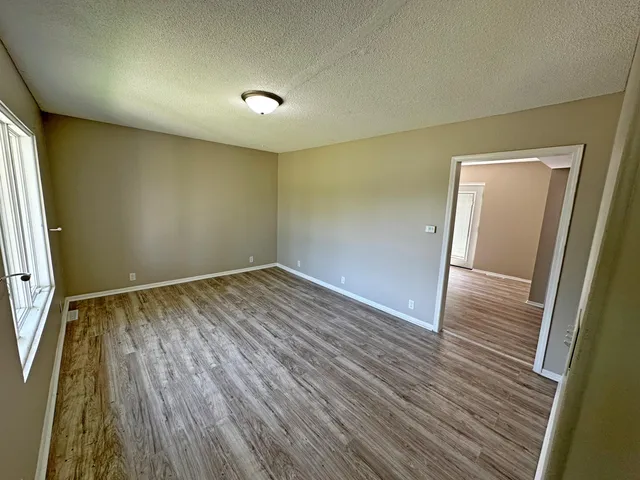 an empty room with wooden floor and entrance