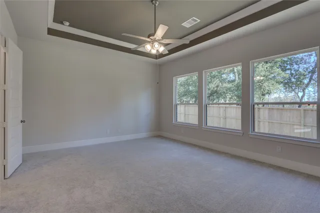 en empty room with windows and chandelier