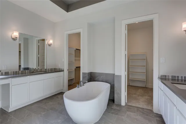 a spacious bathroom with a bathtub sink and mirror