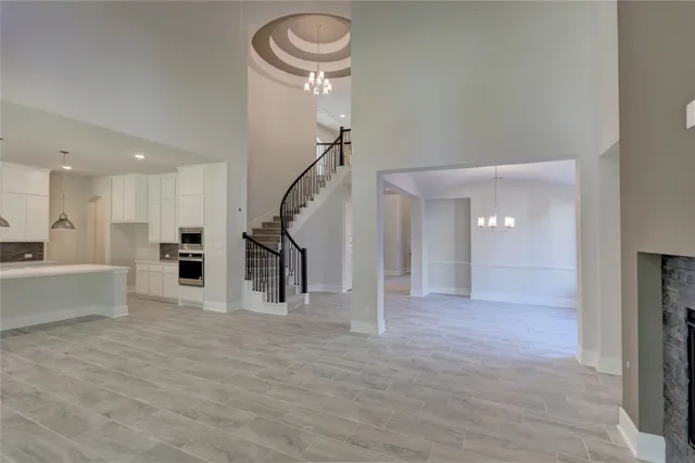 a view of an empty room and a kitchen