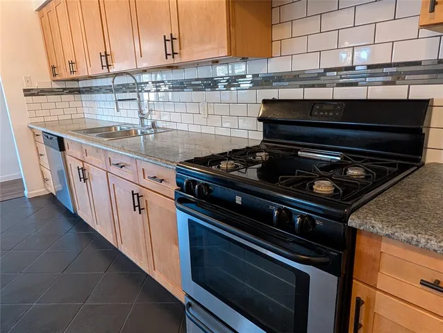 a kitchen with granite countertop a stove and a sink