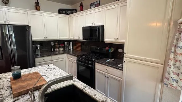 a kitchen with stainless steel appliances granite countertop a stove and a microwave
