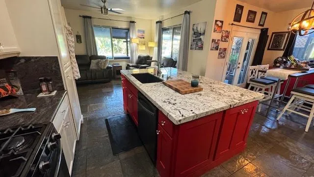 a living room with stainless steel appliances furniture and a view of kitchen