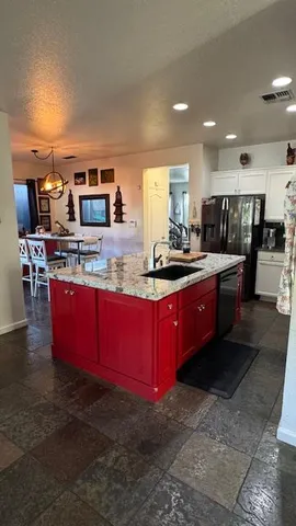 a kitchen with stainless steel appliances granite countertop a stove a sink and a refrigerator