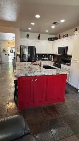 a kitchen with granite countertop a sink stove and cabinets