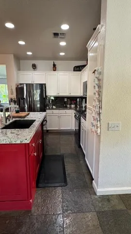 a kitchen with stainless steel appliances granite countertop a stove a sink and a refrigerator
