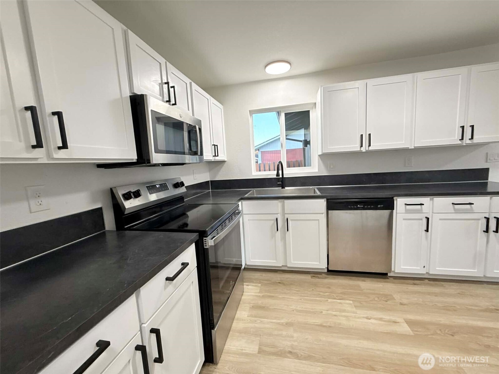 1807 Harding Road Aberdeen, WA 98520 - Photo 11 of 29 a kitchen with stainless steel appliances granite countertop a sink a stove a microwave a sink and cabinets