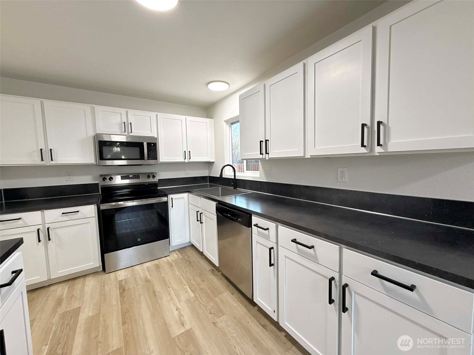 1807 Harding Road Aberdeen, WA 98520 - Photo 10 of 29 a kitchen with granite countertop white cabinets and black appliances