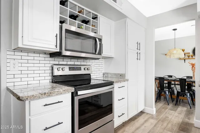 a kitchen with granite countertop cabinets stainless steel appliances and wooden floor