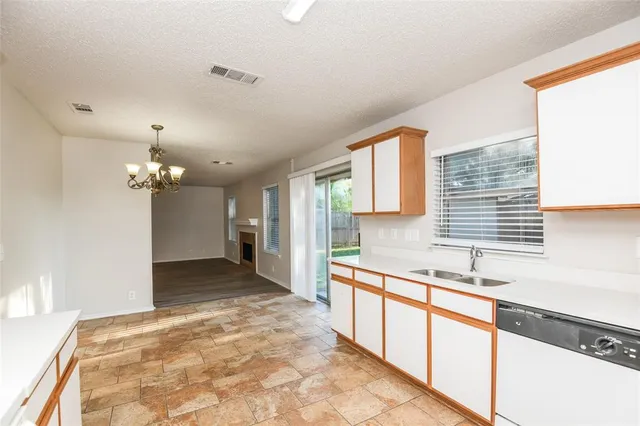 a large kitchen with kitchen island a sink wooden floor and a chandelier