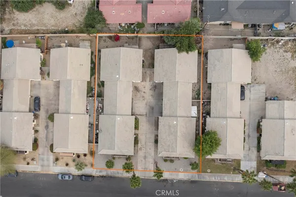 an aerial view of residential houses with outdoor space and parking