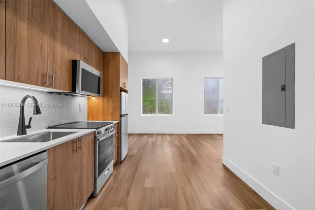 a kitchen with stainless steel appliances a stove a microwave and a refrigerator