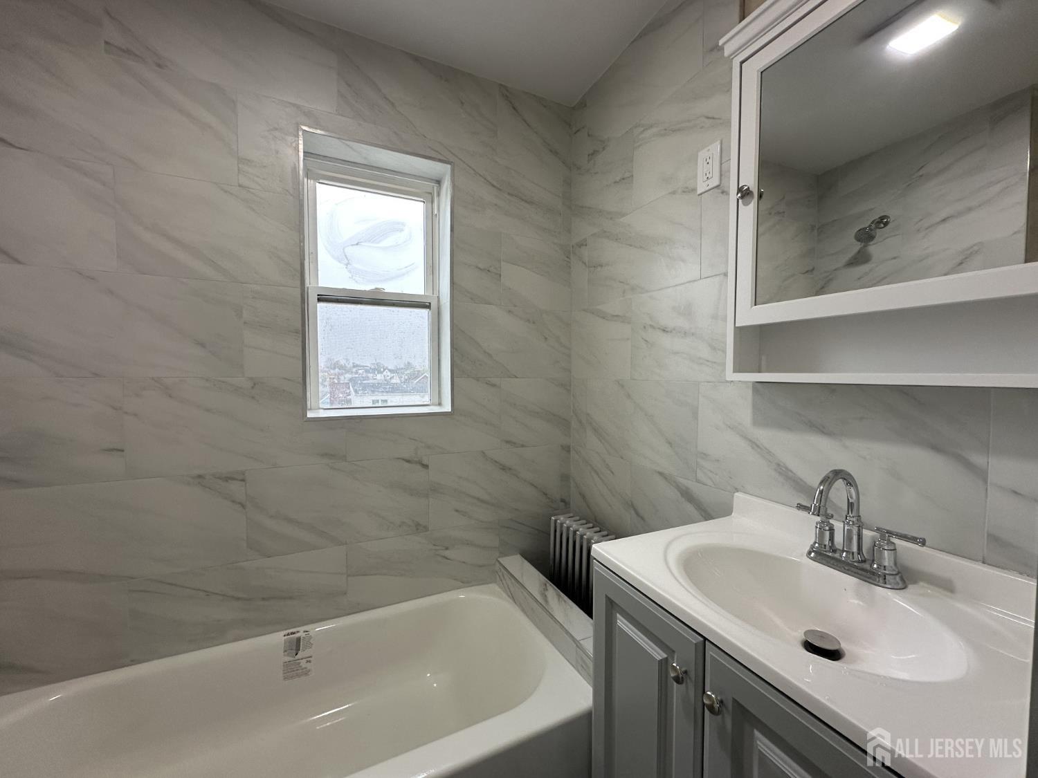 618 Carlock Avenue Perth Amboy, NJ 08861 - Photo 3 of 9 a bathroom with a sink and a bathtub