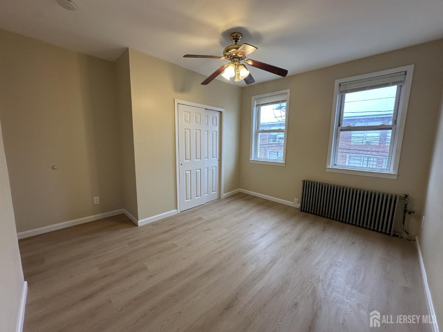 618 Carlock Avenue Perth Amboy, NJ 08861 - Photo 5 of 9 a view of an empty room with wooden floor and a window