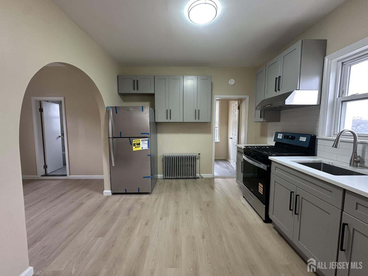 618 Carlock Avenue Perth Amboy, NJ 08861 - Photo 7 of 9 a kitchen with stainless steel appliances granite countertop a refrigerator a sink dishwasher and wooden cabinets with wooden floor