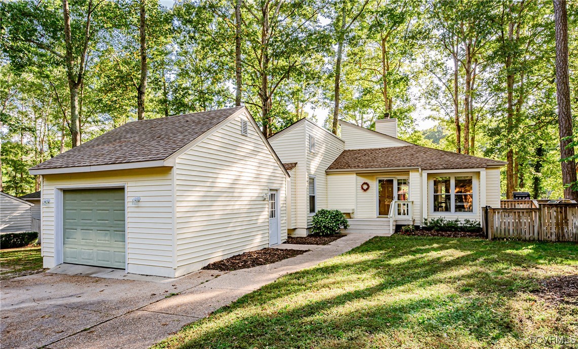 a view of a house with a yard and large tree