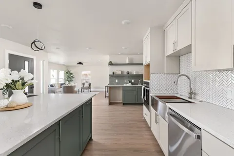 a kitchen with kitchen island a sink appliances cabinets and a counter top space