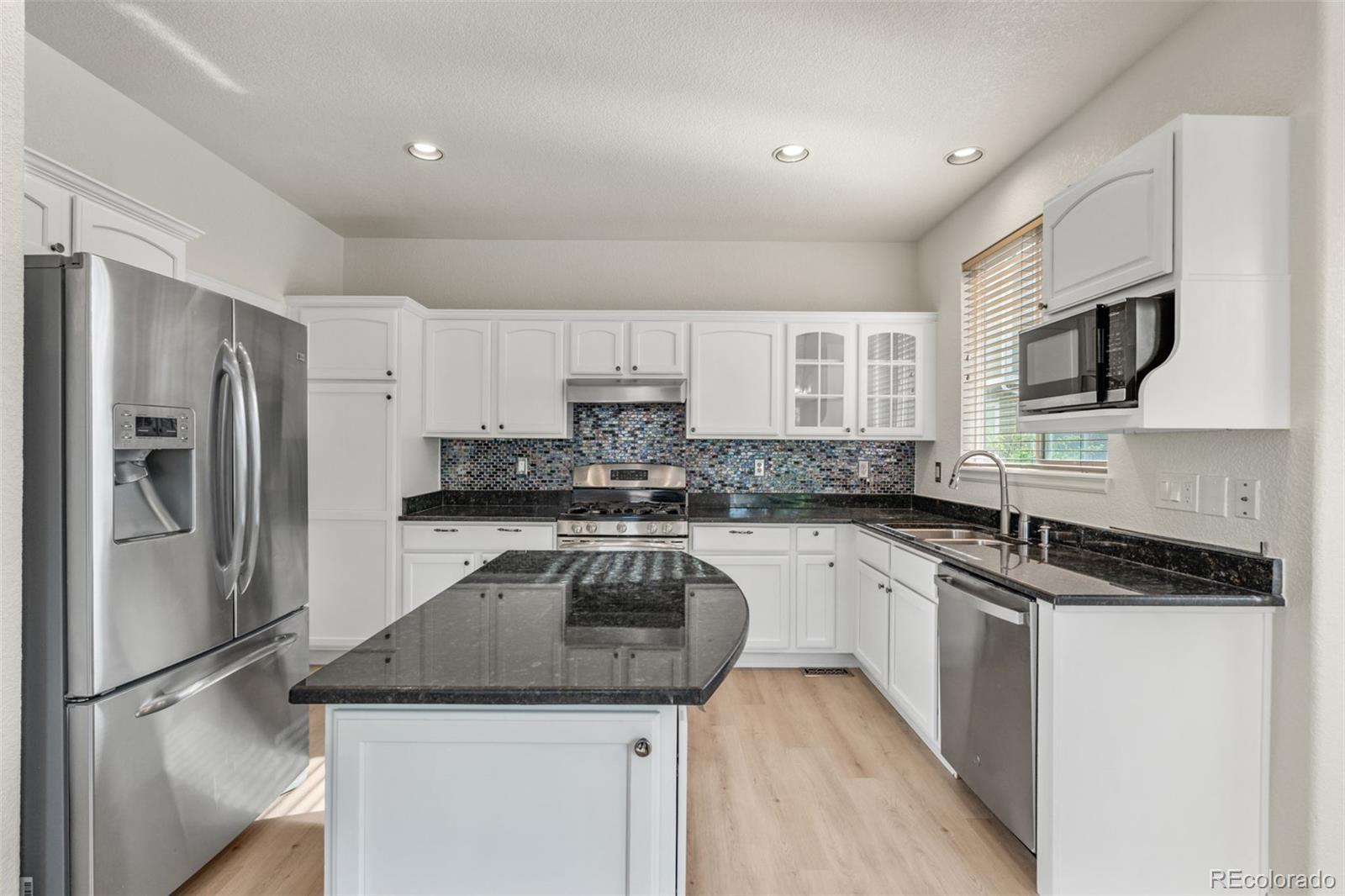 10665 Evondale Street Highlands Ranch, CO 80126 - Photo 11 of 45 a kitchen with a refrigerator sink and microwave