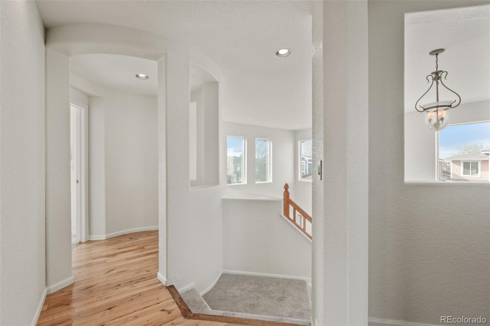 10665 Evondale Street Highlands Ranch, CO 80126 - Photo 26 of 45 a view of a hallway with wooden floor and staircase