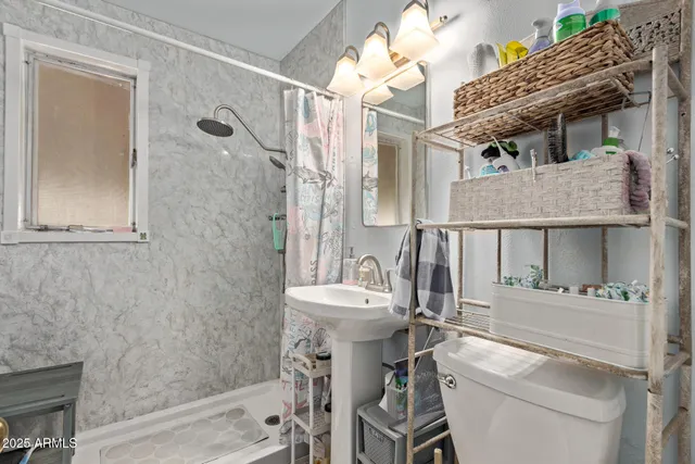 a bathroom with a sink a toilet and shower