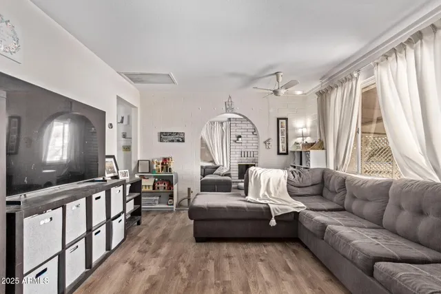 a living room with furniture and a large mirror next to a window