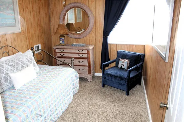a bedroom with a bed a mirror and dresser