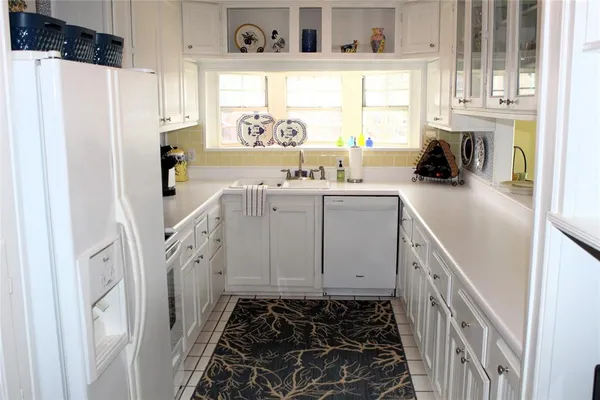 a kitchen with white cabinets and white appliances