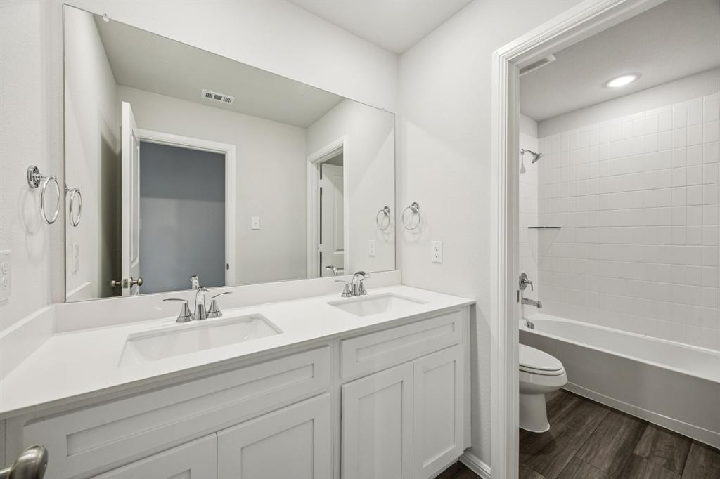425 Magellan Road Seagoville, TX 75159 - Photo 13 of 36 a bathroom with a granite countertop sink toilet a large mirror and shower